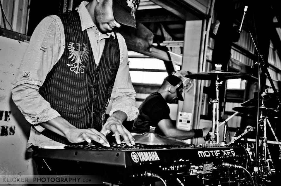 Andre of PAR~A~DIGM playing keyboards in a black and white live photo